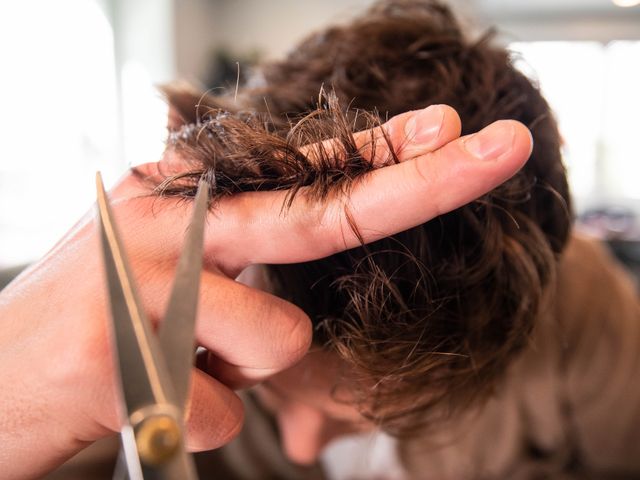 Hairdresser trimming hair with scissors